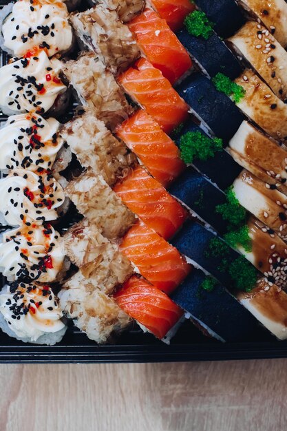 De délicieux sushis colorés et appétissants posés sur l'assiette, y compris différents ingrédients poisson caviar riz concombre saumon sauce soja wasabi graines de sésame Une présentation intéressante