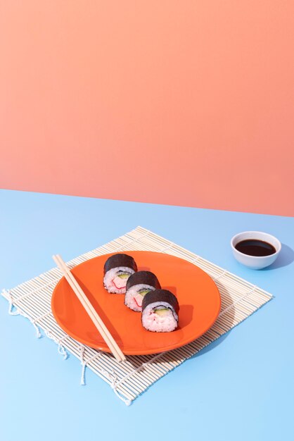 Photo gratuite de délicieux sushis sur plaque avec des baguettes high angle