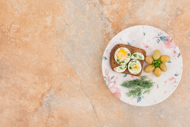 Délicieux toasts avec des œufs durs et des olives sur la plaque