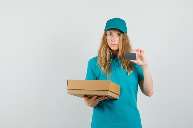 Delivery woman holding boîte en carton et carte en t-shirt, casquette