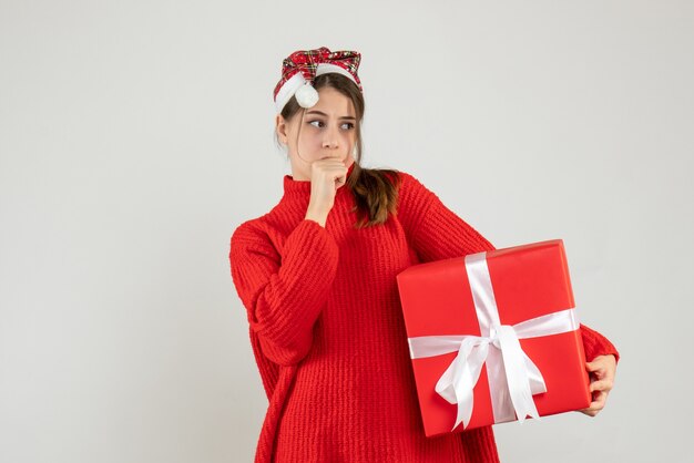 demande fille avec bonnet de noel tenant présent debout sur blanc