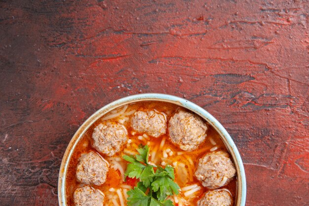 Photo gratuite demi-coup de soupe au poulet avec des nouilles dans un bol marron sur fond sombre