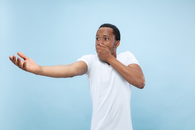 Demi-longueur gros plan portrait de jeune homme afro-américain en chemise blanche sur l'espace bleu