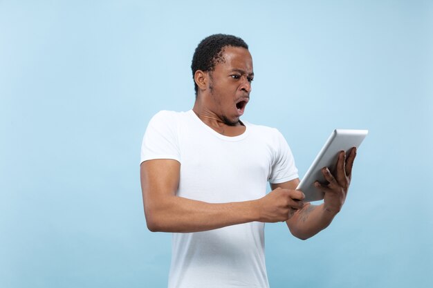 Demi-longueur gros plan portrait de jeune homme afro-américain en chemise blanche sur l'espace bleu