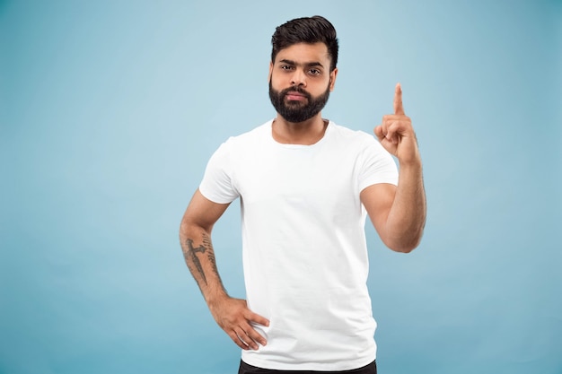 Demi-longueur gros plan portrait de jeune homme en chemise blanche sur bleu