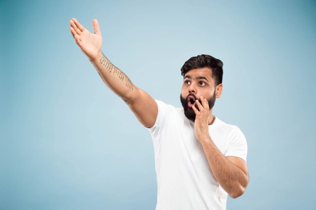 Demi-longueur gros plan portrait de jeune homme hindou en chemise blanche sur l'espace bleu