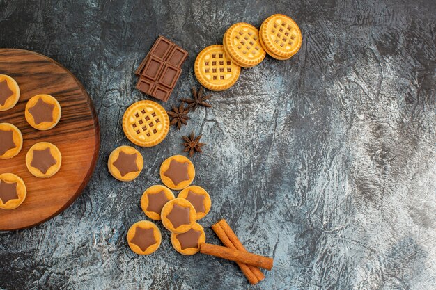 Demi vue des cookies sur un plateau en bois et des cookies de disposition en forme de croissant sur fond gris