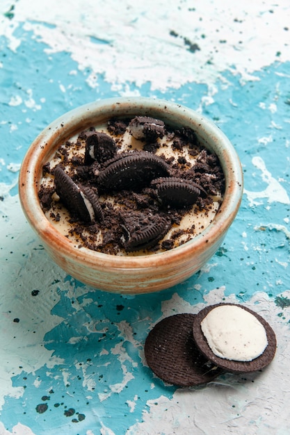 Demi-vue de dessus dessert biscuit au chocolat avec de la crème et des biscuits à l'intérieur de la plaque sur la surface bleue gâteau dessert sucre sucré couleur photo