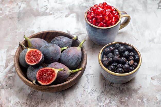 Demi-vue de dessus des figues fraîches avec d'autres fruits sur fond clair