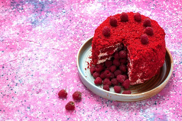 Demi-vue de dessus gâteau aux framboises rouges cuit délicieux à l'intérieur de la plaque sur le bureau rose.