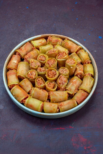 Demi-vue de dessus des rouleaux de viande roulés avec des légumes à l'intérieur de la casserole sur le dîner de la viande de bureau sombre légume repas alimentaire