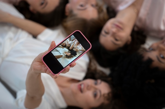 Demoiselles d'honneur souriantes prenant selfie