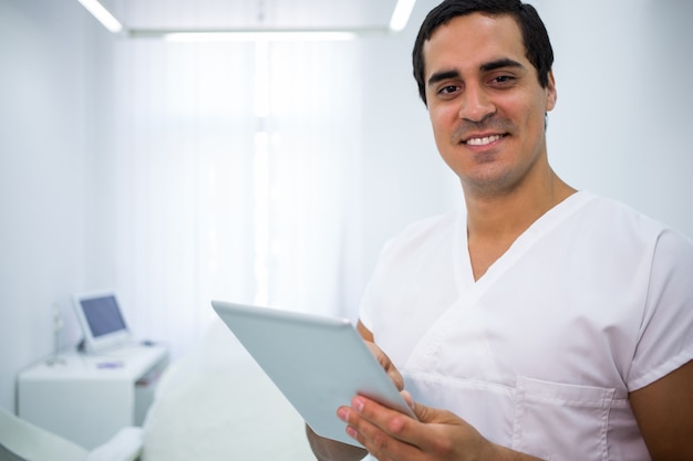 Dentiste à l'aide d'une tablette numérique à la clinique
