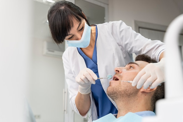 Dentiste faisant un contrôle sur le patient