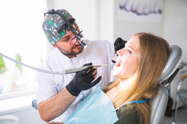 Dentiste faisant un traitement dentaire sur une patiente