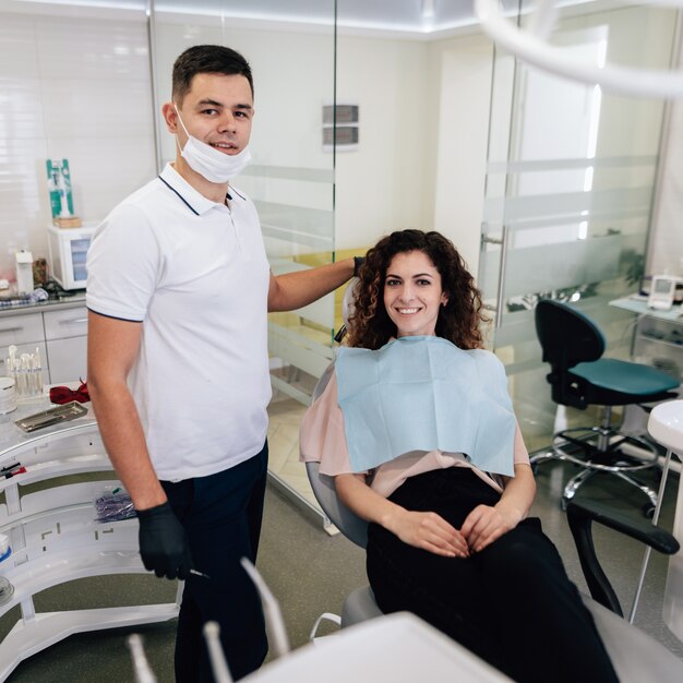 Dentiste et patient posant et souriant