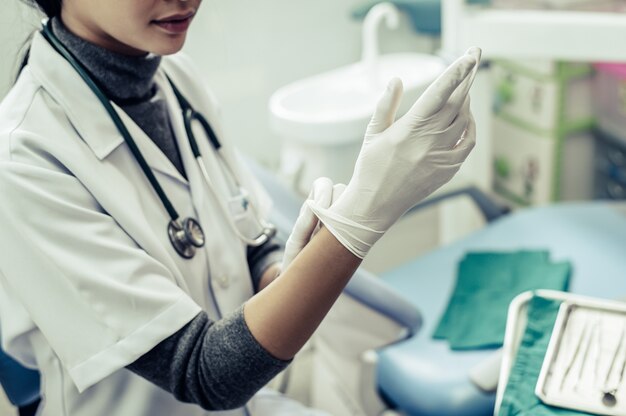 Le dentiste porte des gants.