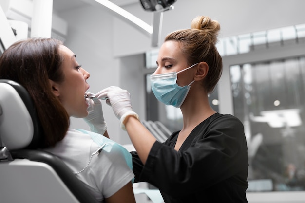 Dentiste à tir moyen portant un masque