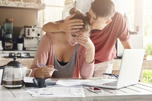 Déprimé jeune femme tenant un stylo, calcul du budget familial