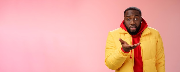 Dérangé grossier ignorant afro-américain barbu pointant l'appareil photo de la paume l'air muet perplexe debout