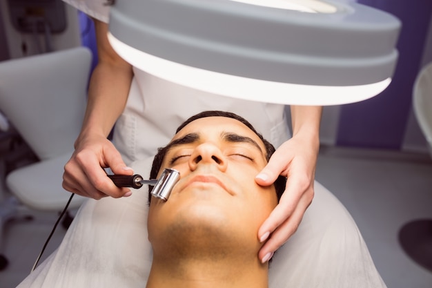 Photo gratuite dermatologue effectuant une épilation au laser sur un patient