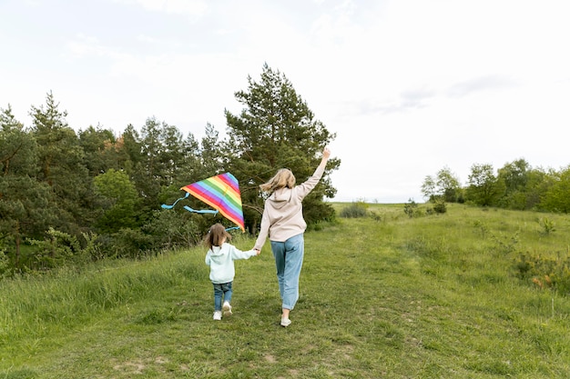 De derrière boutique maman et enfant jouant avec cerf-volant