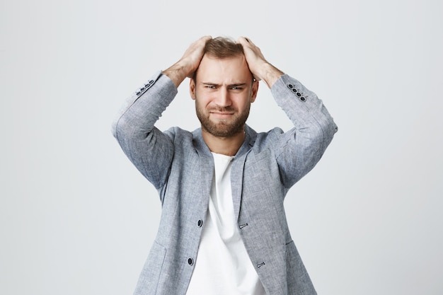 Photo gratuite désespéré ennuyé homme agacé saisir la tête dérangé