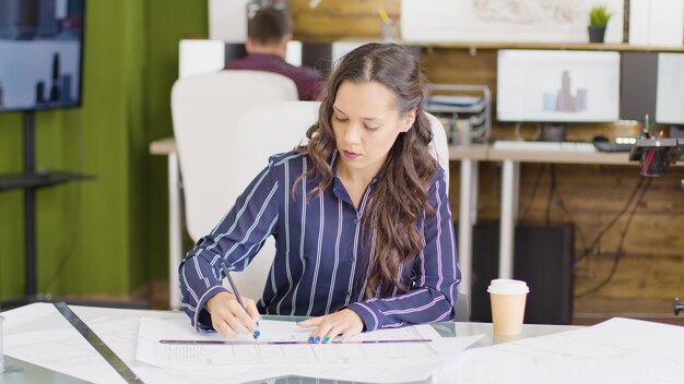 Designer dans un espace de bureau créatif travaillant sur un nouveau projet à sa table