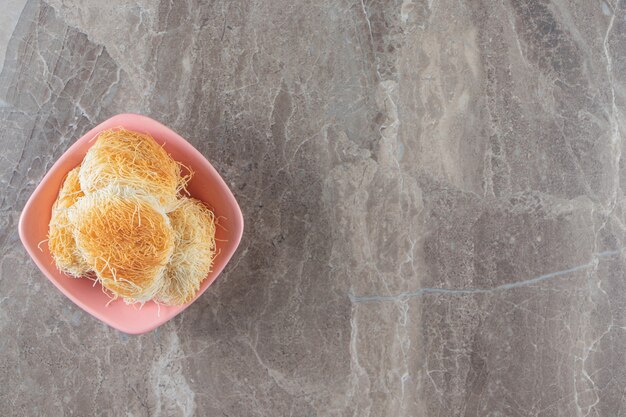 Dessert turc kadayif dans un bol sur marbre.