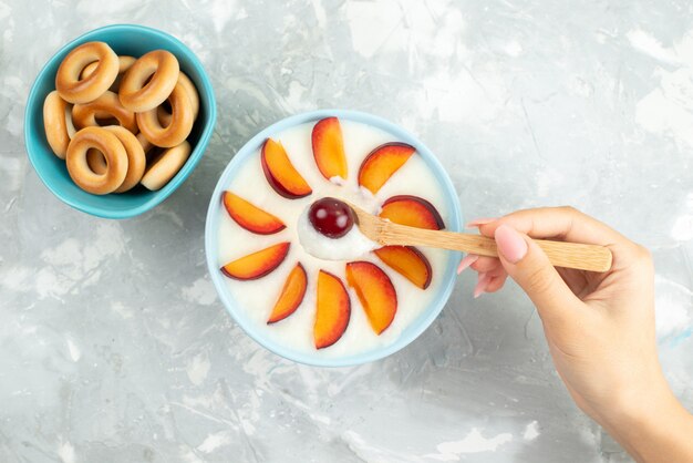 Dessert vue de dessus avec des fruits en tranches de fruits à l'intérieur de la plaque avec des craquelins sucrés sur gris