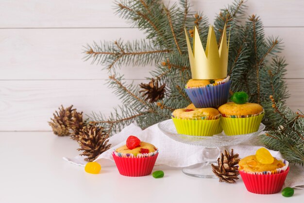 Desserts du jour de l'Épiphanie sur la table avec couronne et épicéa