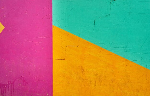 Détail abstrait du mur avec des fragments de graffitis colorés.