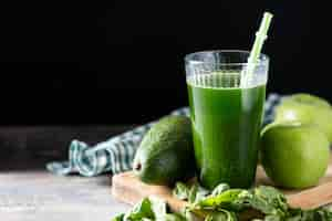 Photo gratuite détox de smoothie vert avec avocat kale et pommes sur table en bois