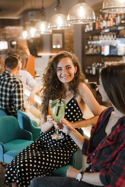 Deux amies appréciant cocktail dans le pub