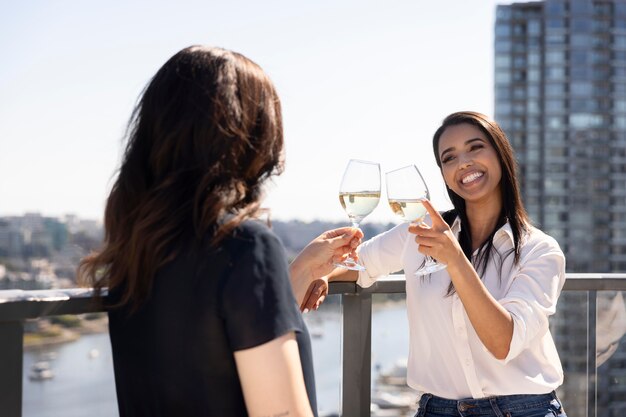 Deux amies discutant et dégustant du vin sur un toit-terrasse