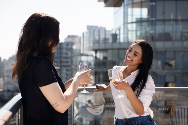 Deux amies discutant et dégustant du vin sur un toit-terrasse