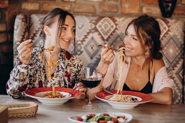 Deux amies de manger des pâtes dans un restaurant italien