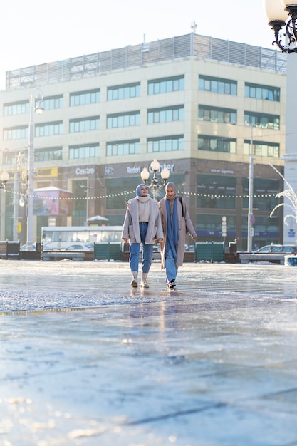 Photo gratuite deux amies musulmanes se promenant dans la ville lors d'un voyage