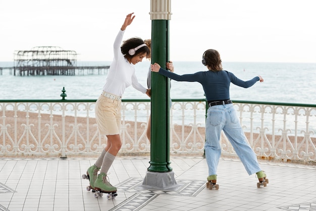 Photo gratuite deux amies avec des patins à roulettes roulant à l'extérieur