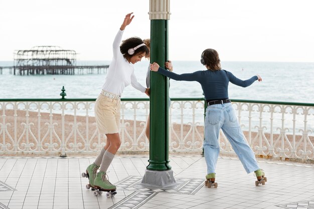 Deux amies avec des patins à roulettes roulant à l'extérieur