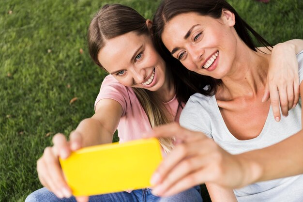 Deux amies prenant un selfie à l'extérieur