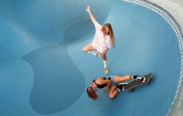 Photo gratuite deux amies s'amusant à faire du skateboard