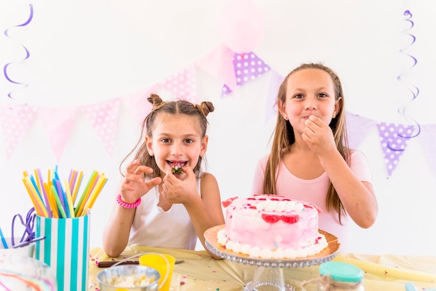 Photo gratuite deux amies en train de manger un gâteau tout en profitant d'une fête d'anniversaire