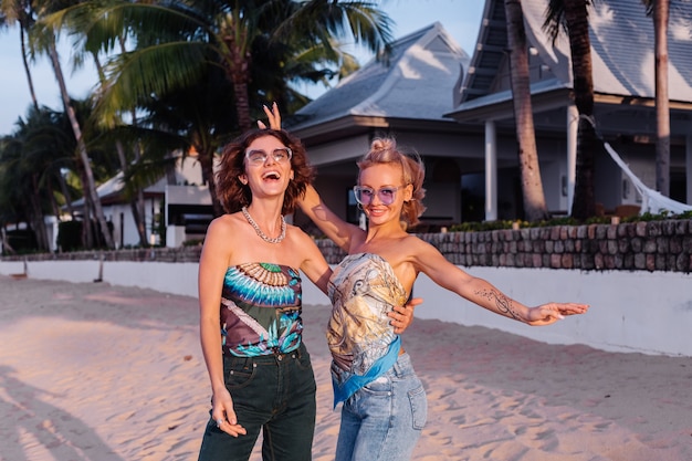 Deux amis femme heureuse avec des lunettes de soleil en vacances dans un pays tropical