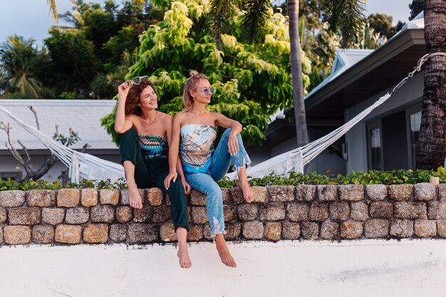 Deux amis femme heureuse avec des lunettes de soleil en vacances dans un pays tropical