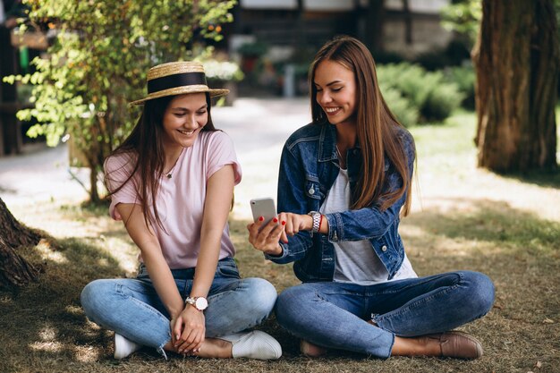 Deux amis filles assis dans un parc