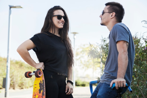 Deux amis avec longboard et vélo