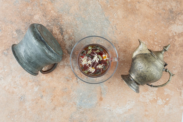 Deux anciennes théières avec tisane sur fond de marbre