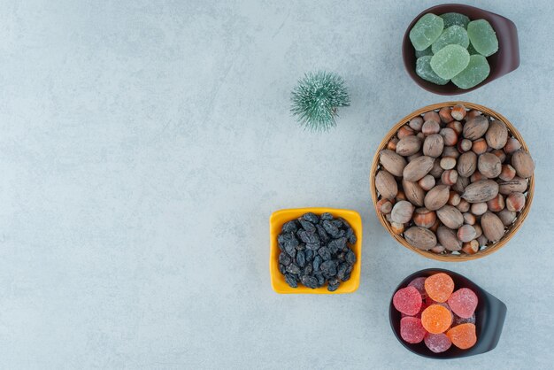 Photo gratuite deux assiette sombre de marmelade de sucre avec bol en bois plein de noix. photo de haute qualité