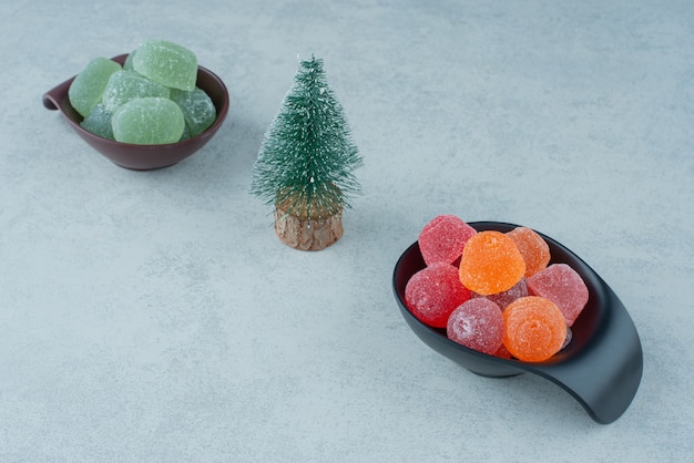 Deux assiettes foncées de marmelade de sucre avec petit sapin de Noël. Photo de haute qualité